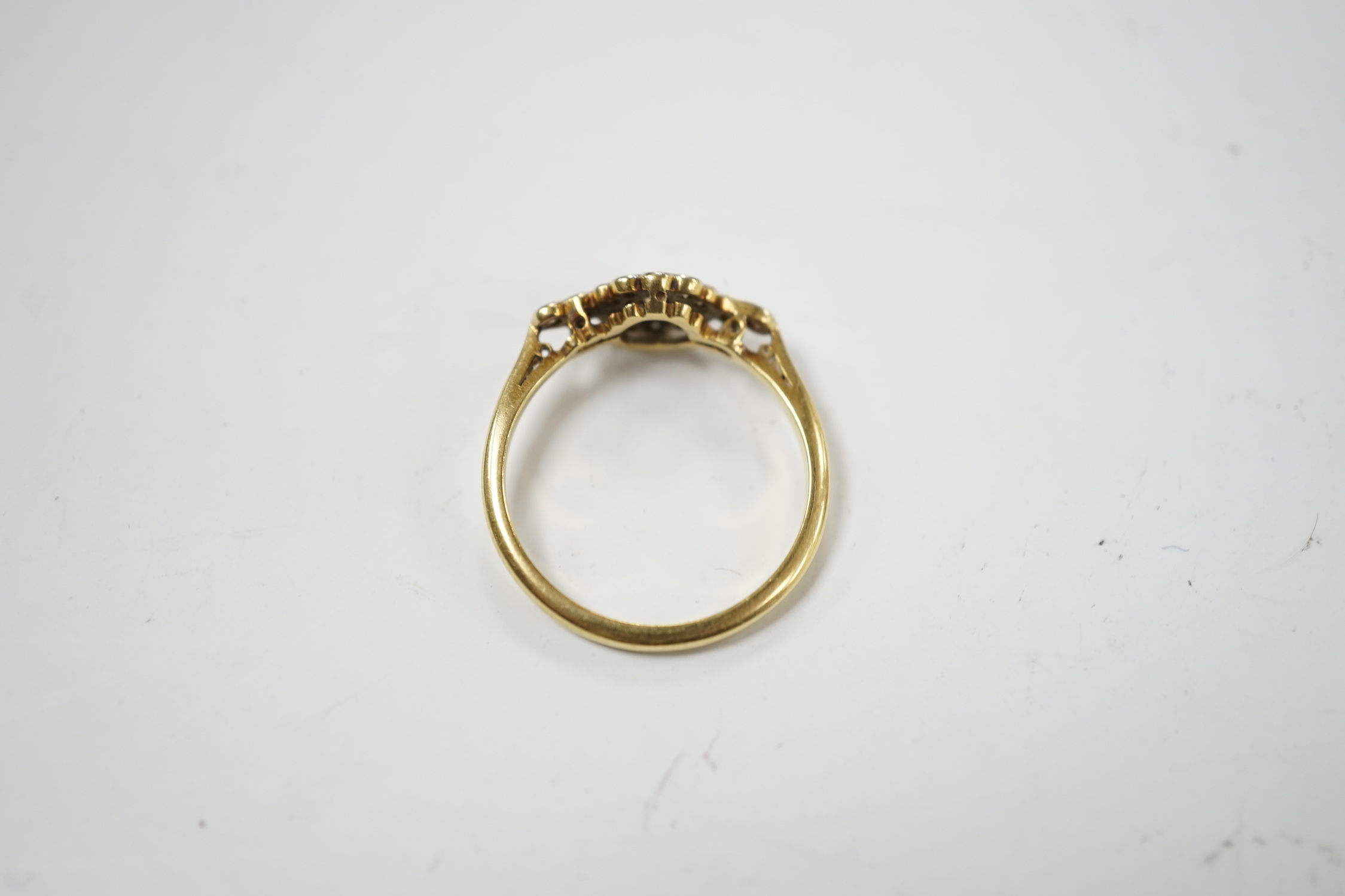 A Belle Epoque 18ct, plat and diamond cluster set target ring, with diamond set shoulders, size P, gross weight 2.6 grams.